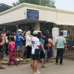 People stand outside Ateneo de Zamboanga University after a shooting that killed two people on Aug. 18.