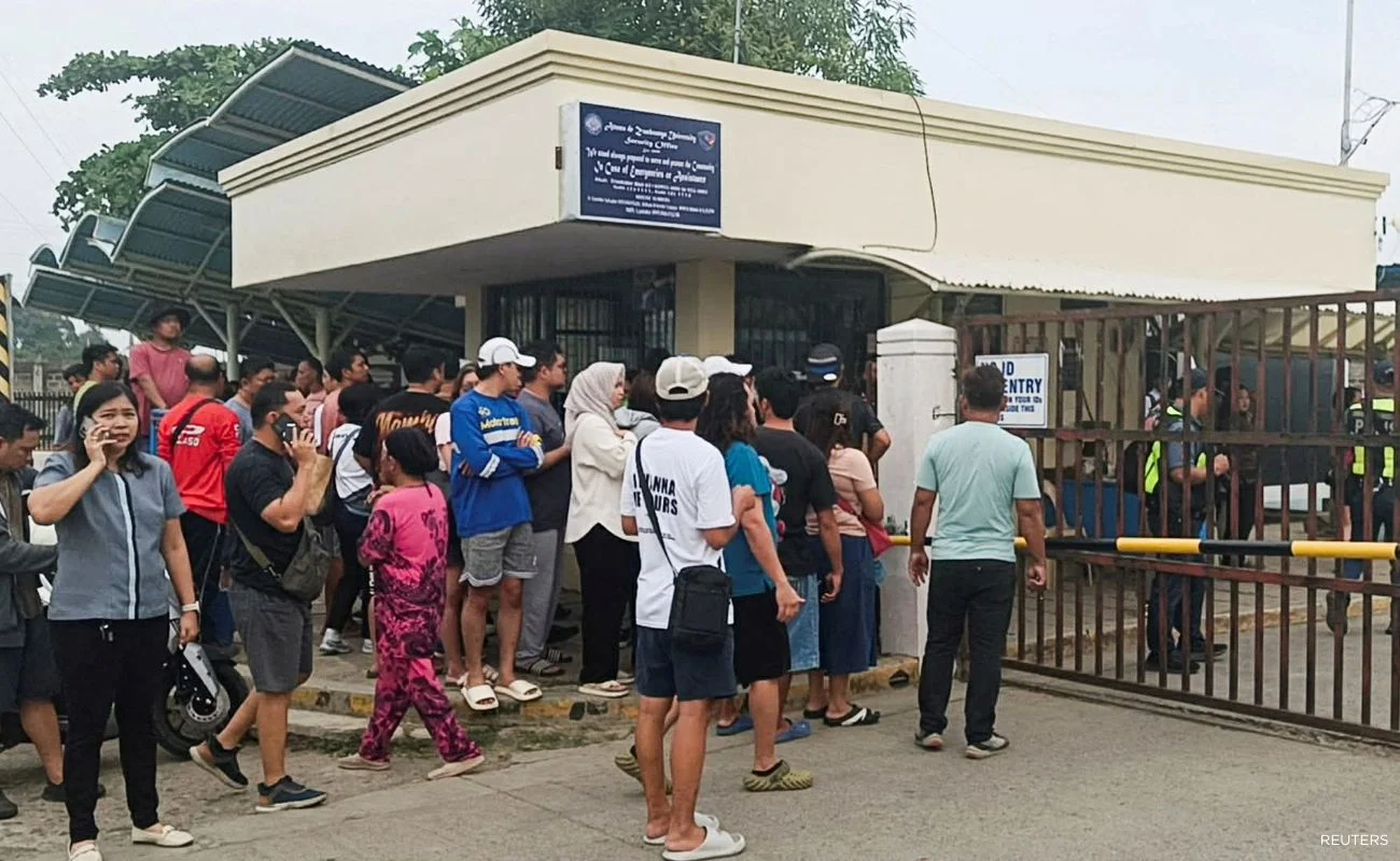 People stand outside Ateneo de Zamboanga University after a shooting that killed two people on Aug. 18.