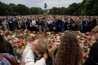 Mourners gather to pay their respects outside the Royal Palace, following the death of Norway's King Harald, in Oslo, Norway, August 28, 2026. (NTB/Cornelius Poppe)